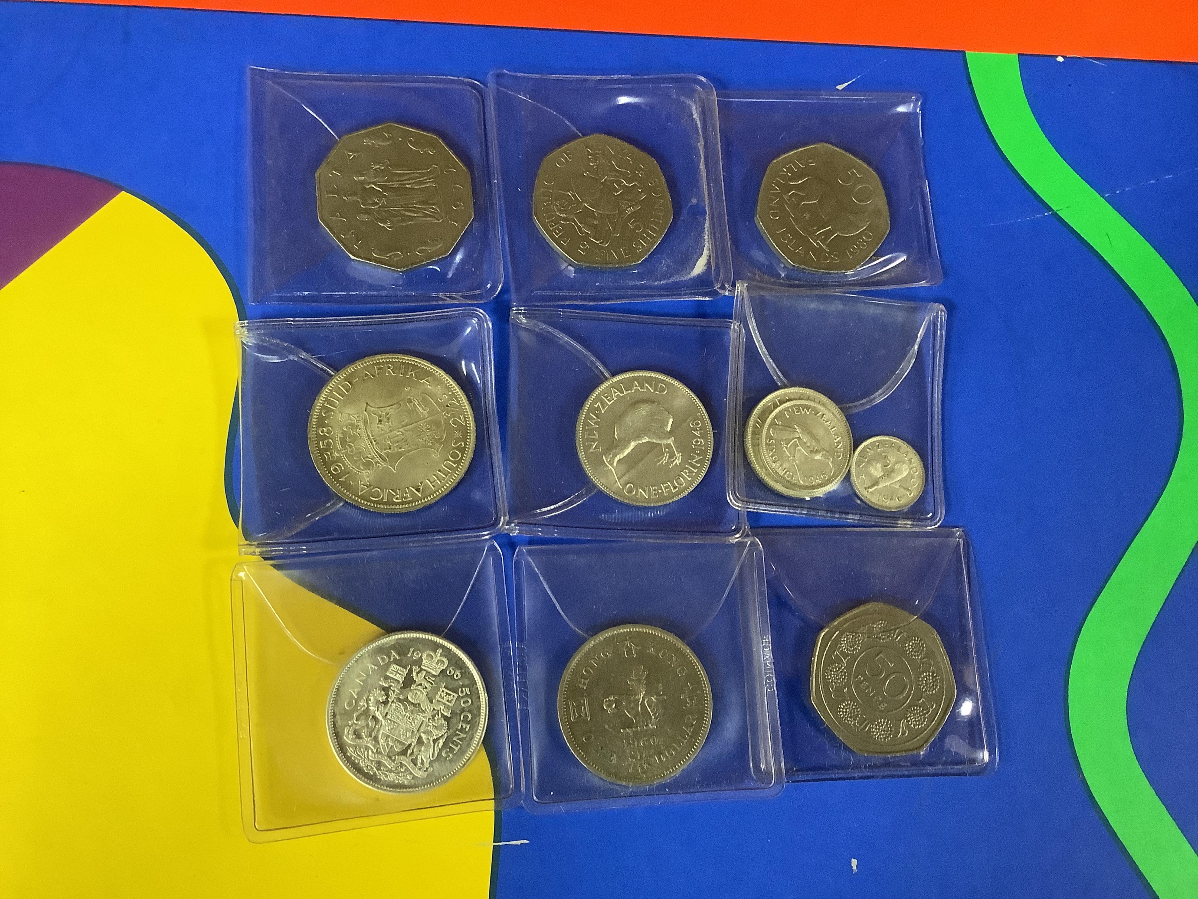 World coins and banknotes, including ‘crowns of the world’ Bermuda, Canada South Africa etc some may be replicas, in three albums, together with examples in clear plastic wallets the majority 1950 or later